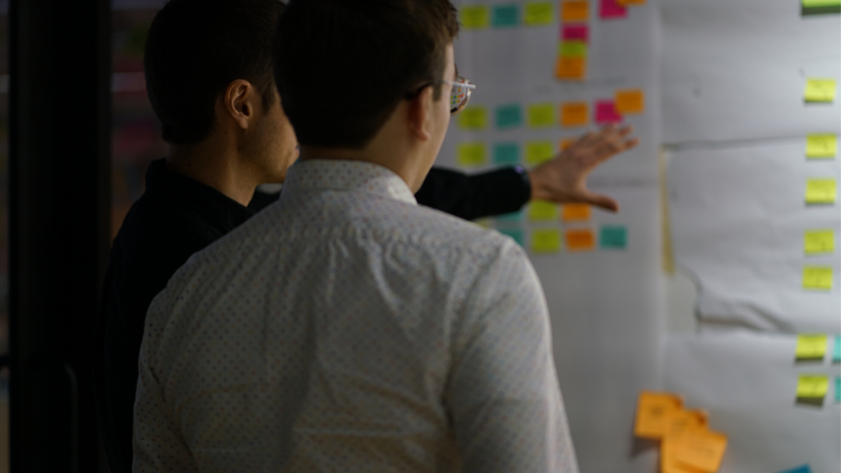 two men looking at idea board